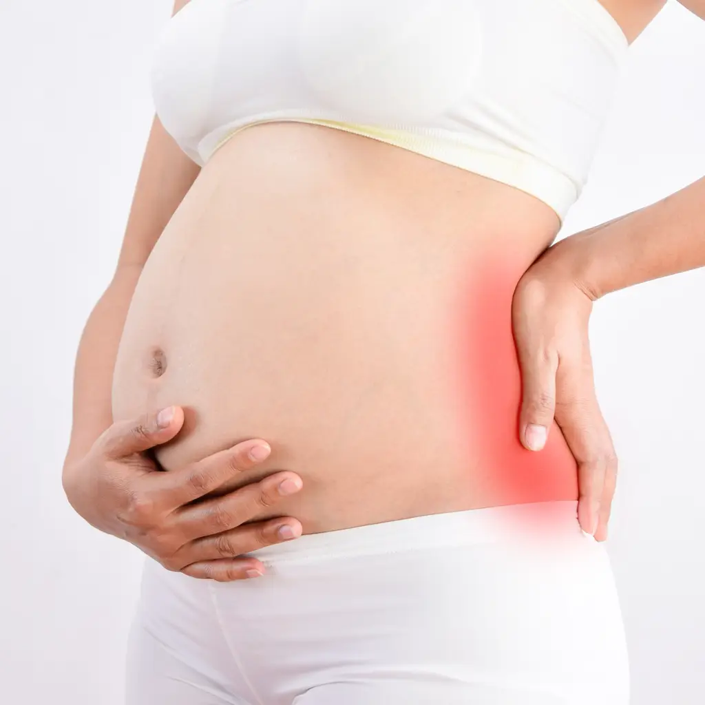 pregnant woman holding painful area of her back